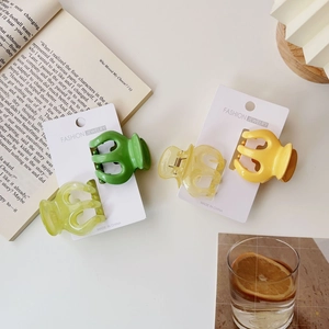 Set of four small jelly-colored pumpkin hair claws in green and yellow resin finish