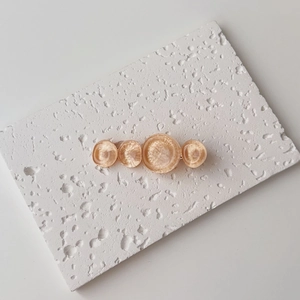 Macro detail of amber resin circles on elegant gold metal hair clip for women