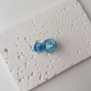 Macro view of blue marble-patterned resin hair clip with dual disk geometric design