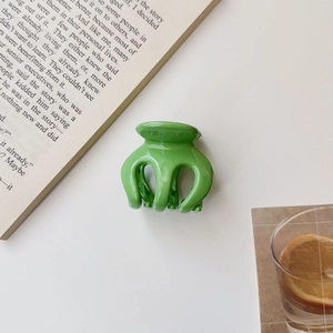 Close-up of jelly green pumpkin hair claw clip with glossy finish on a white background