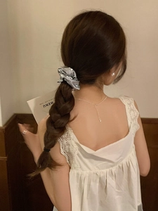 Elastico per capelli metallizzato argento su coda intrecciata con texture setosa
