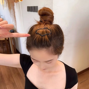 Dettaglio di un fermaglio per capelli nero a forma di nuvola per lo chignon