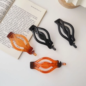 Detail shot of matte and glossy wave hair claws on an open book with modern aesthetic