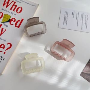 Three jelly-colored rectangular hair claws in matte taupe, soft pink, and cream white