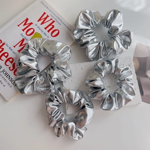Dettaglio di quattro elastici per capelli argento metallizzato con trama plissettata