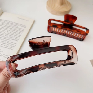Close-up of rectangular amber tortoiseshell hair claw clips with hollow design