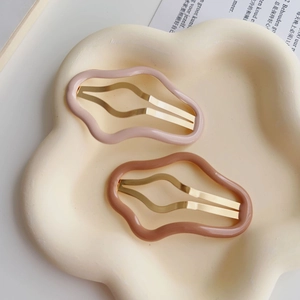 Dettaglio di fermagli per capelli a forma di nuvola rosa e marroni su un vassoio