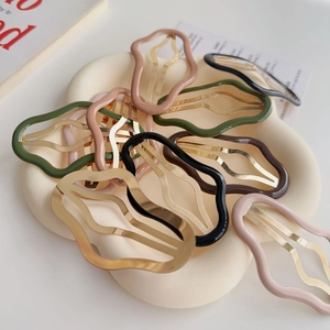 Macro di fermagli per capelli a nuvola colorati su un vassoio in ceramica floreale
