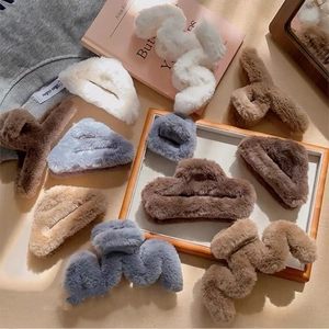 Close-up of assorted plush faux fur hair claws in neutral earth tones on soft background