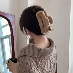 Detail of a large khaki plush hair claw clip showing soft faux rabbit fur texture
