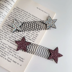 Primo piano di pettini per capelli a stella con strass scintillanti su un libro