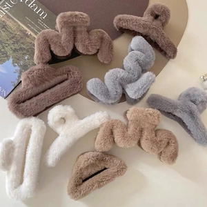 Collection of plush claw clips in earthy tones like brown and khaki for hair styling