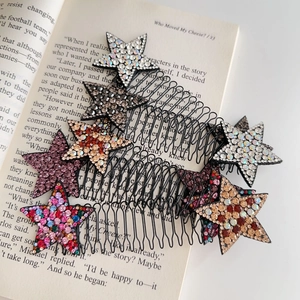 Dettaglio di pettini per capelli a forma di stella con strass su sfondo libro