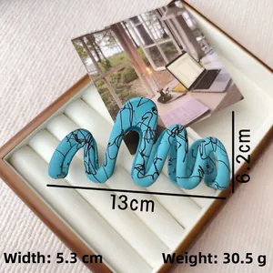 Detail view of wavy sky blue hair claw clip with black ink splatter texture, 13cm size