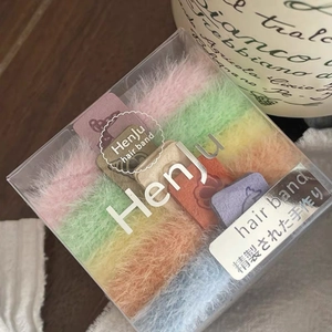 Vue détaillée d'élastiques à cheveux en peluche colorés dans leur boîte de rangement