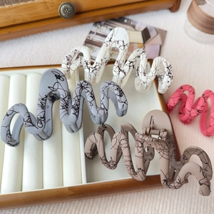 Ink splash wavy matte hair claws in white, grey, brown, and pink on a jewelry tray