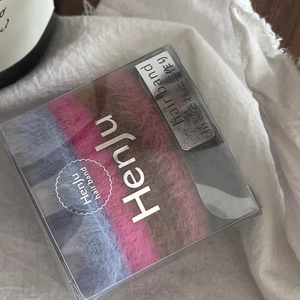 Détails d'un ensemble de chouchous colorés en peluche dans une boîte cadeau transparente