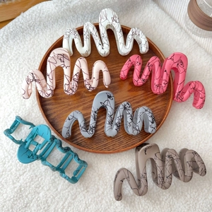 Matte wave-patterned hair claws with abstract graffiti design in assorted pastel colors