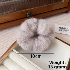 Macro detail of a soft grey faux mink fur scrunchie showing 10cm size and 16g weight