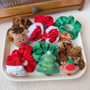 Makroansicht der Weihnachts-Haargummis mit Samttextur, Rentier- und Weihnachtsmann-Motiven