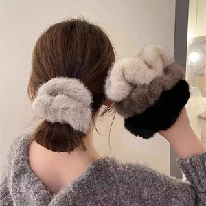 Detailed view of plush faux fur hair scrunchies in gray, khaki, brown, and black