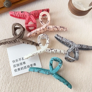 Large matte resin shark hair clips in six colors with ink textures on ribbed fabric