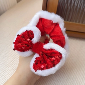 Nahaufnahme von Weihnachts-Haargummi mit roter Pailletten-Schleife und Plüschstruktur