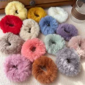 Flat lay of colorful plush hair scrunchies in diverse warm autumn shades and soft textures