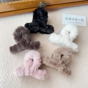 Vista dall'alto di pinze per capelli in peluche in nero marrone bianco rosa e beige