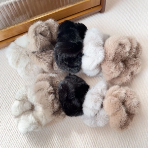 Close-up of fluffy faux fur scrunchies in cream, coffee, black and grey tones