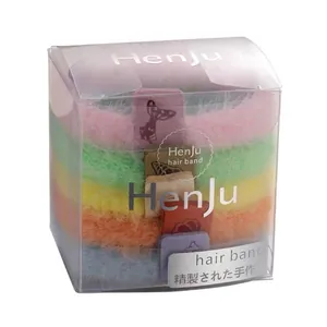 Lot de chouchous en peluche colorés dans une boîte transparente, rose, jaune et bleu