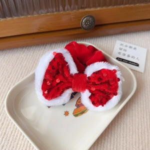 Detail eines roten Samt-Weihnachtshaargummis mit Pailletten und weißem Pelzbesatz