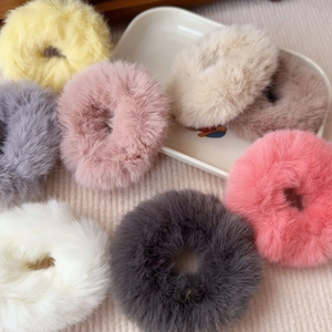 Detailed view of plush faux fur scrunchies set in various pastel colors for winter