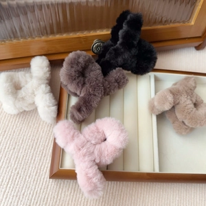 Pinze per capelli in peluche nero, caffè, rosa, beige e marrone chiaro su espositore