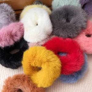 Close-up of assorted colorful plush hair scrunchies with soft faux fur texture for girls