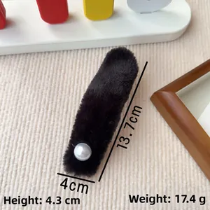Nahaufnahme einer schwarzen Plüsch-Haarklammer mit Perle und Maßangabe von 13,7 cm Länge