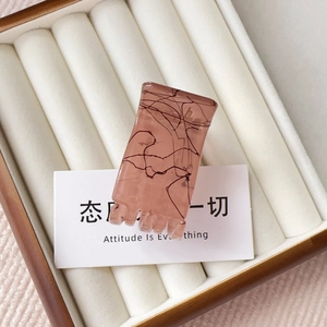 Detail view of pink marble matte hair claw clip for ponytail in jewelry display box