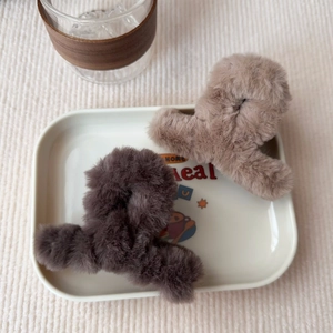 Dettaglio di piccole pinze per capelli in peluche marrone scuro e chiaro su un vassoio