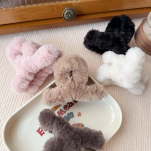 Dettaglio del set di 5 mollette per capelli in peluche rosa, nero, crema e marrone