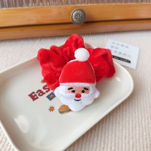 Detail eines festlichen Samt-Haargummis mit einer 3D-Weihnachtsmann-Plüschfigur