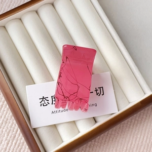 Detail view of pink matte hair claw clip with marble texture in a soft gift box