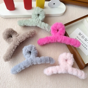 Nahaufnahme von fünf bunten Plüsch-Haarklammern in Minze, Rosa, Braun, Blau und Pink
