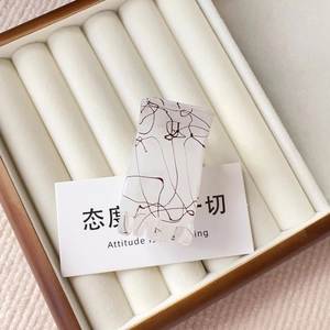 Close-up of matte ivory rectangular hair claw clip with brown silk texture in a box