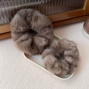 Close-up of two brown faux mink fur scrunchies on a white tray for autumn and winter