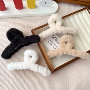 Nahaufnahme von weichen Plüsch-Haarklammern in Schwarz, Weiß und Beige auf dem Tisch