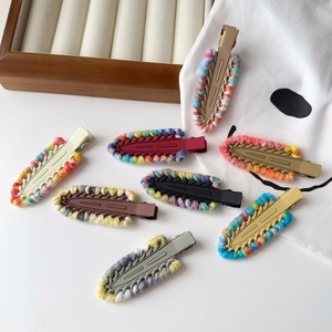 Detailed macro view of colorful hand-knitted wool textured duckbill hair clips for women