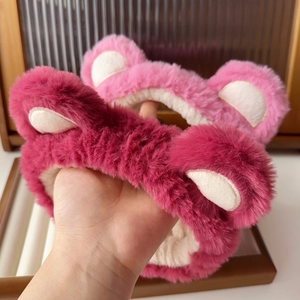 Close-up of soft pink plush strawberry bear headband with cute animal ears for skincare