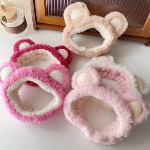 Detail view showing four plush bear ear headbands in various colors on wooden surface