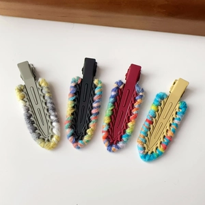 Detailed view of 4 pieces of knit wool duckbill hair clips in various trendy color patterns