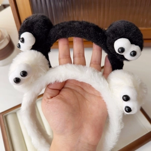 Close-up of cute black and white plush headbands with cartoon eyes for hair styling
